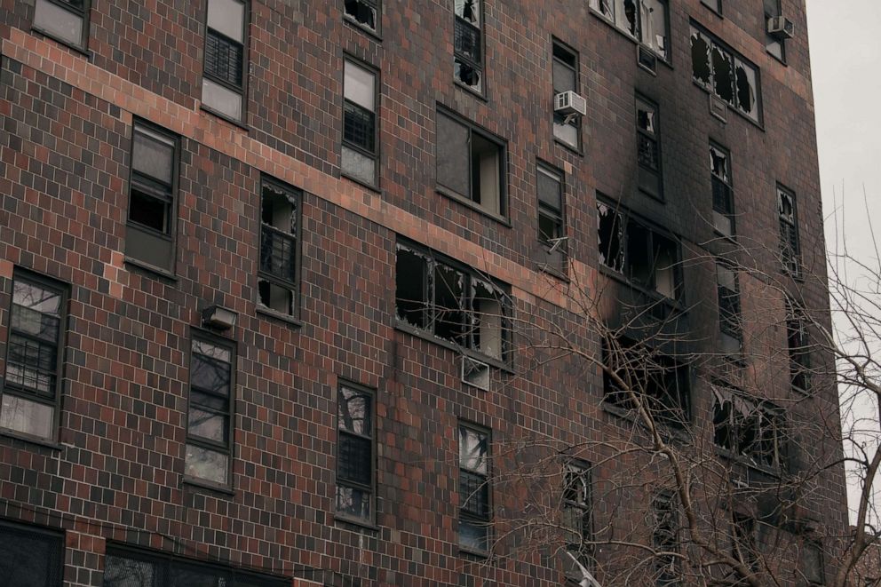 Broken windows and charred bricks mark the exterior of a 19-story residential building after a fire erupted in the morning, Jan. 9, 2022, in the Bronx, New York City.